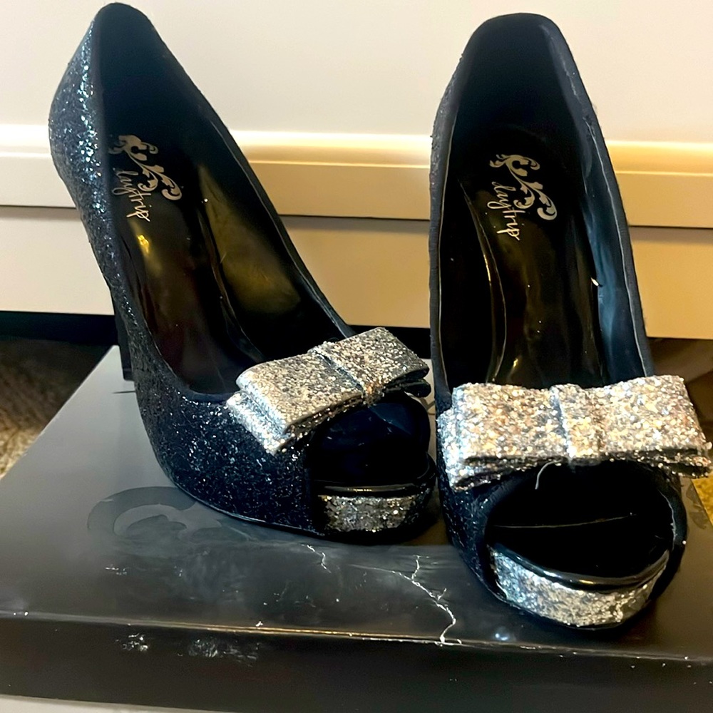 Daytrip black glitter peep toe heels with a silver glitter bow.